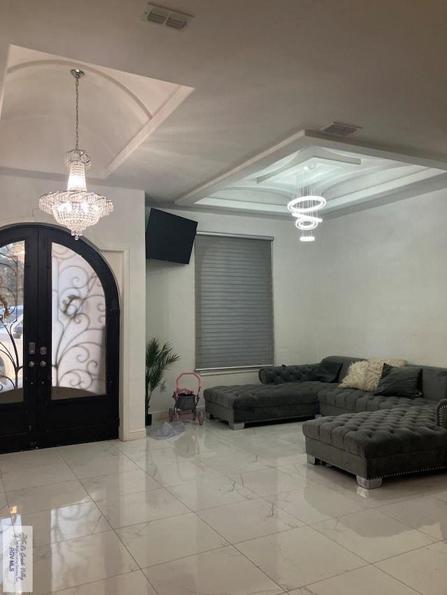 foyer entrance featuring french doors and a chandelier