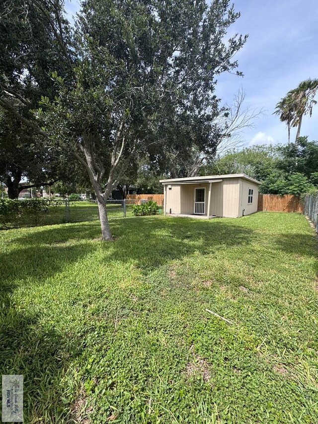 2326 Rio Hondo Rd, Harlingen, TX 78550 - fenced backyard featuring an outbuilding