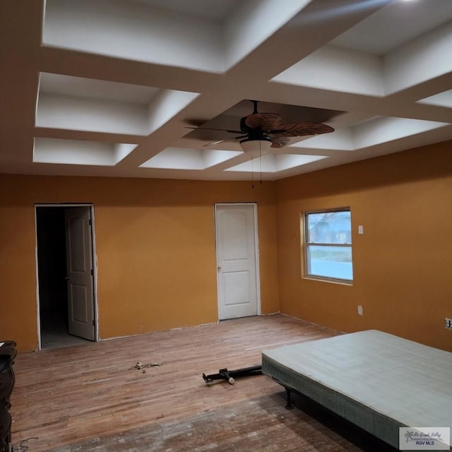 unfurnished bedroom featuring ceiling fan, wood-type flooring, and coffered ceiling