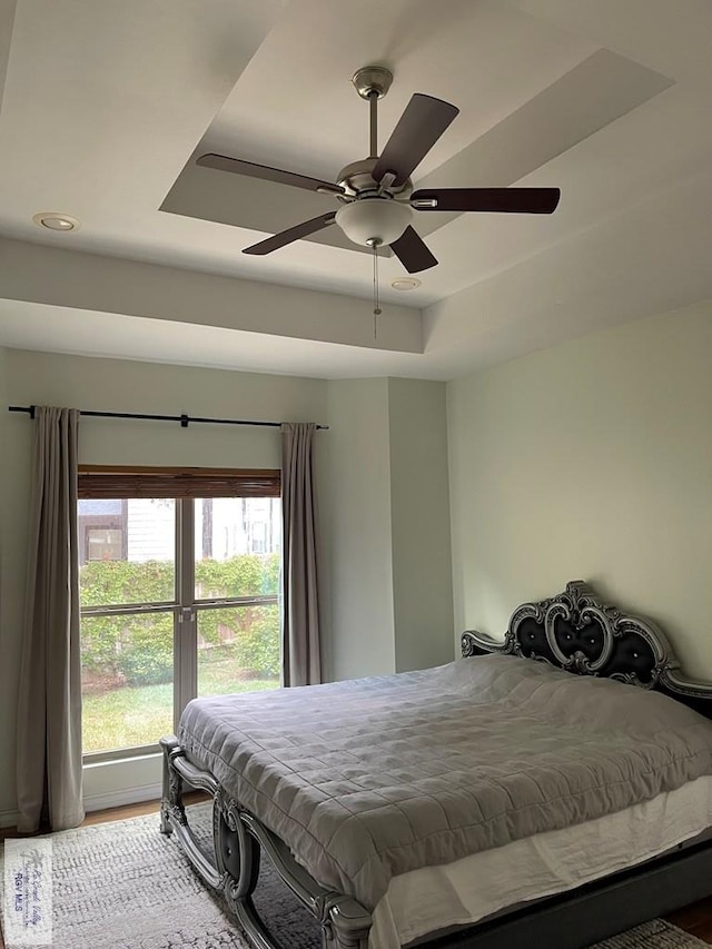 bedroom featuring ceiling fan and a tray ceiling