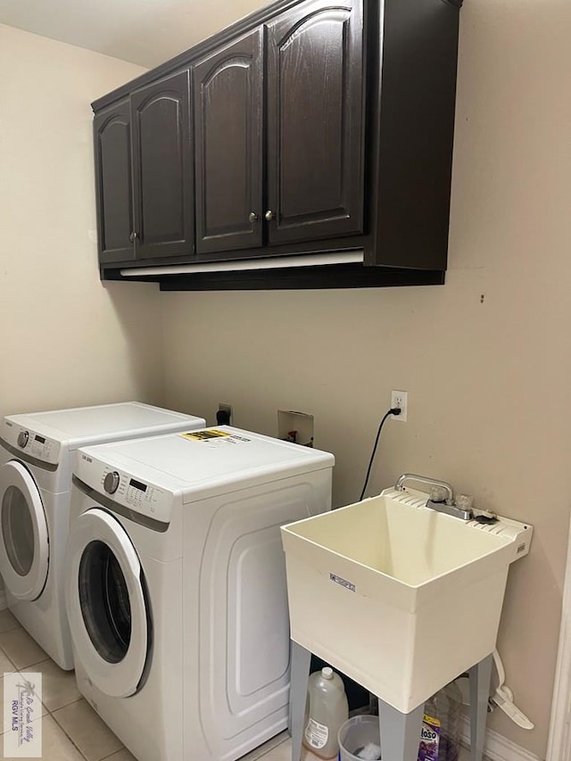 laundry room featuring independent washer and dryer, cabinets, light tile patterned floors, and sink