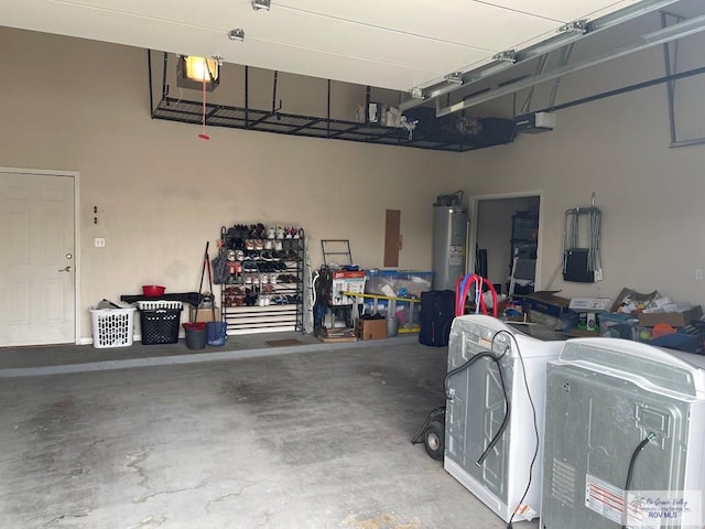 garage with a garage door opener, washer and clothes dryer, and water heater