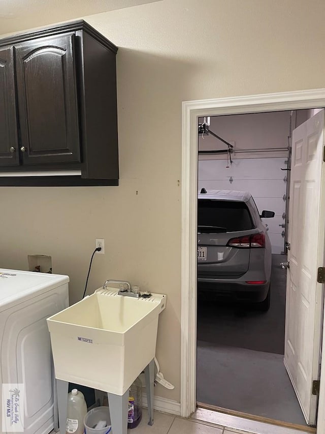 washroom with cabinets, washer / dryer, and sink