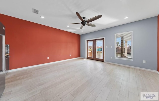 unfurnished room with french doors, ceiling fan, and light wood-type flooring