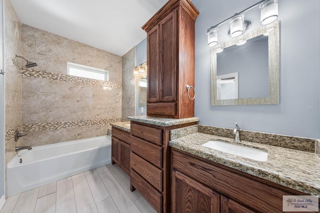 bathroom with vanity and tiled shower / bath