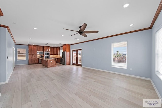 unfurnished living room with ceiling fan, ornamental molding, and light hardwood / wood-style floors