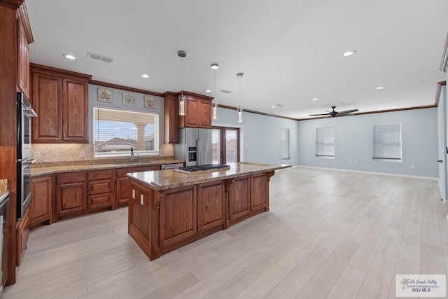 kitchen with sink, a center island, pendant lighting, stainless steel appliances, and decorative backsplash