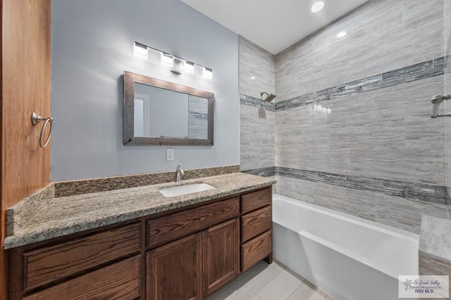 bathroom featuring vanity, tiled shower / bath combo, and tile patterned flooring