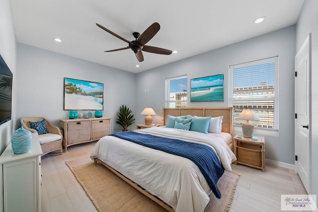 bedroom featuring multiple windows, ceiling fan, and light wood-type flooring