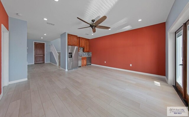 unfurnished living room featuring plenty of natural light, light hardwood / wood-style floors, and ceiling fan