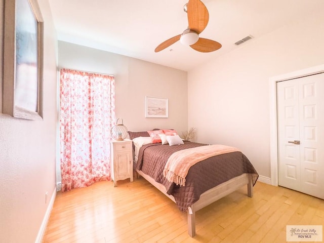 bedroom with ceiling fan, a closet, and light hardwood / wood-style flooring