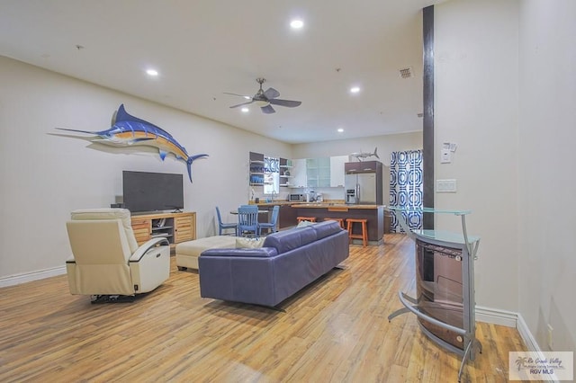 living room featuring ceiling fan and light wood-type flooring