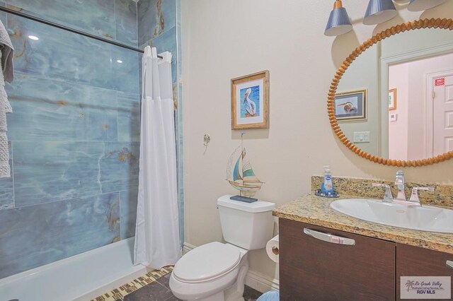 full bathroom featuring tile patterned floors, shower / bath combo with shower curtain, vanity, and toilet