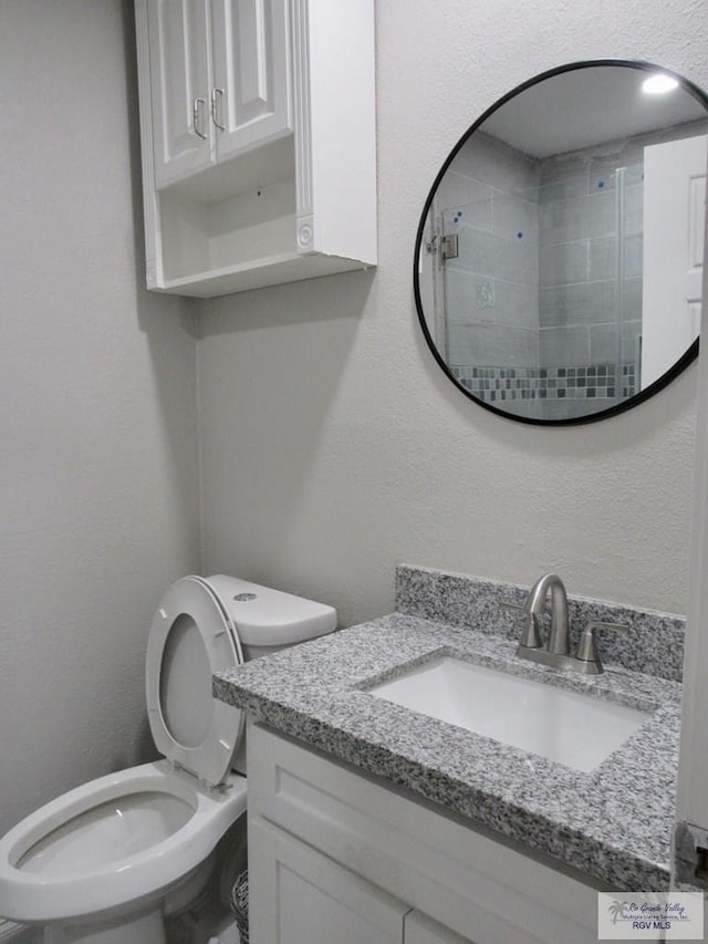 225 Country Club Rd Unit 225, Brownsville, TX 78520 - bathroom featuring a textured wall, toilet, a tile shower, and vanity