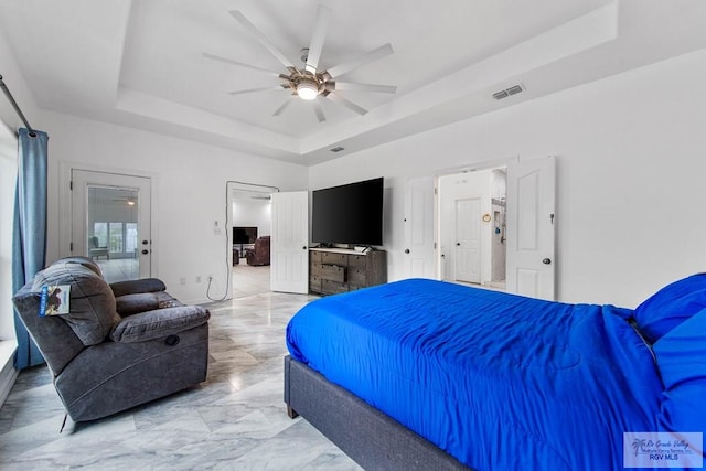 bedroom with a tray ceiling and ceiling fan