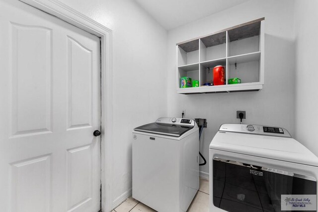 laundry room featuring washing machine and dryer and light tile patterned floors