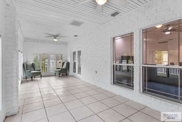 unfurnished sunroom featuring ceiling fan