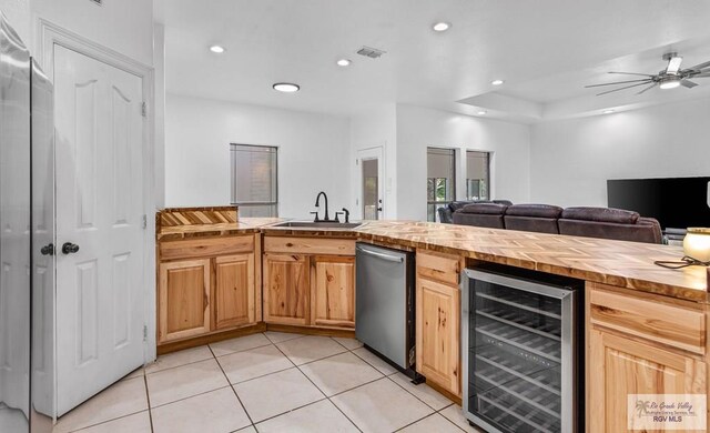 kitchen featuring wooden counters, light tile patterned floors, wine cooler, and sink