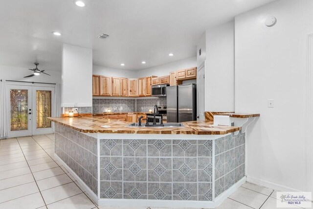 kitchen featuring kitchen peninsula, sink, french doors, and appliances with stainless steel finishes