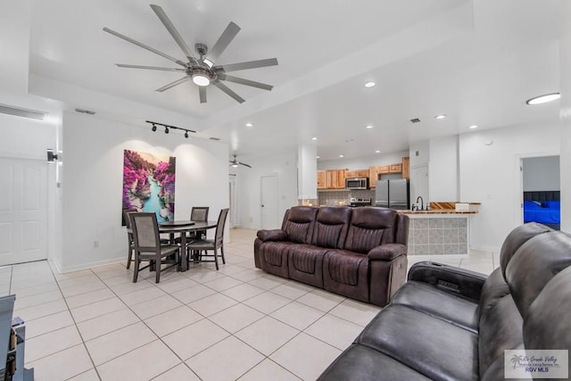 tiled living room with ceiling fan and sink