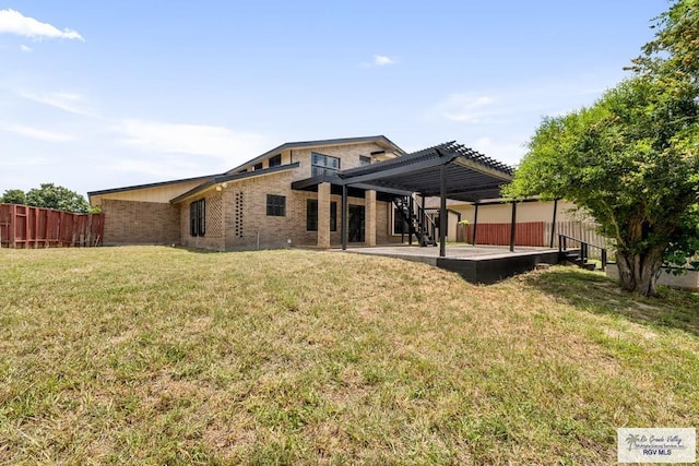 rear view of house featuring a yard, a pergola, and a patio