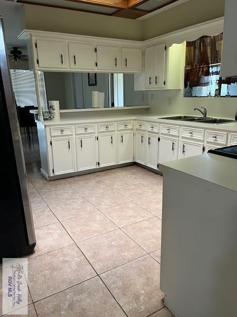 kitchen featuring white cabinetry, sink, and light tile patterned floors