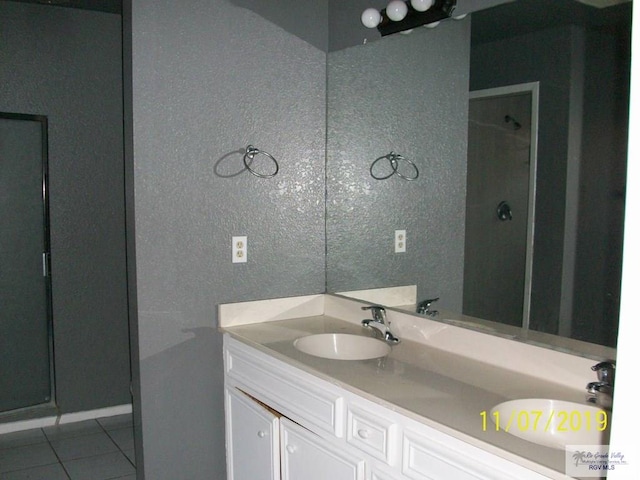 bathroom with tile patterned flooring, vanity, and a shower with shower door