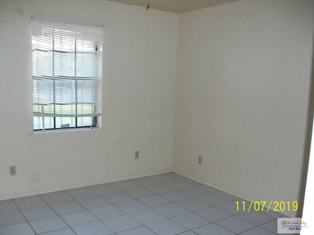 empty room featuring a wealth of natural light and light tile patterned flooring