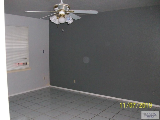 spare room with light tile patterned floors and ceiling fan