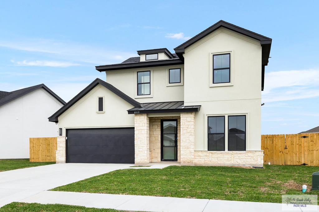 8919 Zoar Lk, Brownsville, TX 78520 - modern inspired farmhouse featuring concrete driveway, stone siding, a standing seam roof, metal roof, and fence