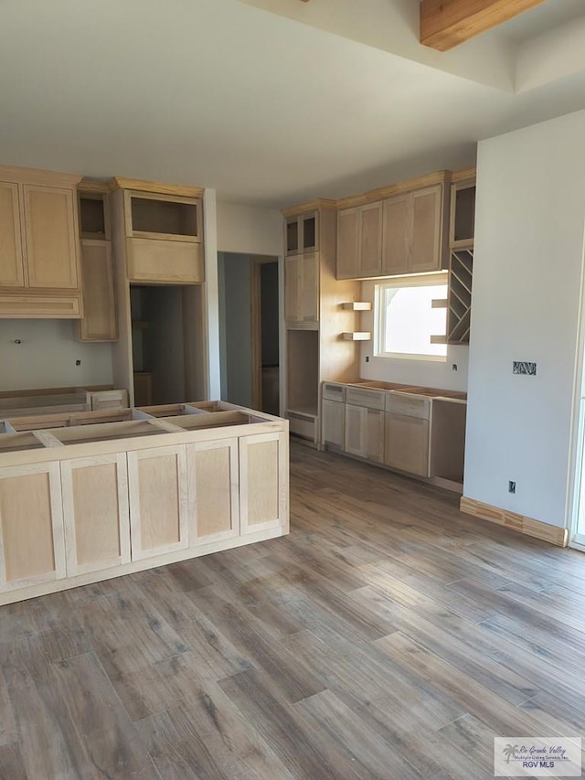 9728 Heights S Unit 9, Harlingen, TX 78552 - kitchen featuring wood finished floors, light brown cabinets, and a baseboard radiator