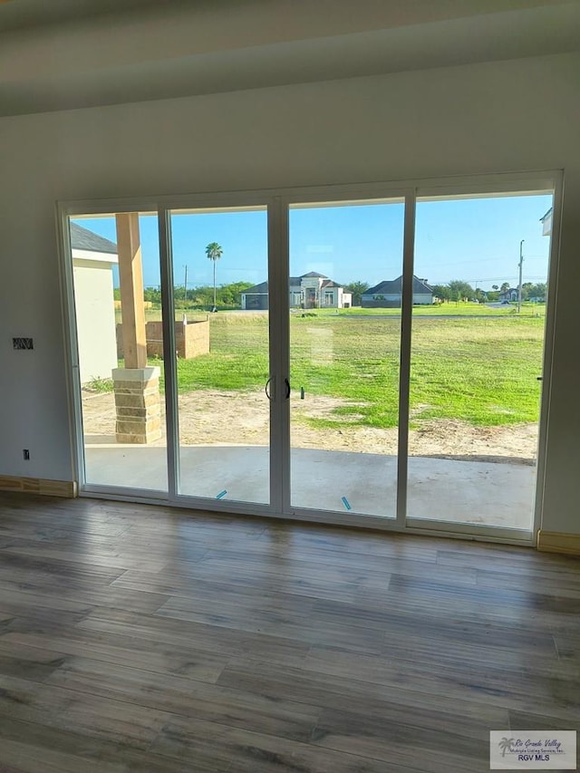 9728 Heights S Unit 9, Harlingen, TX 78552 - doorway featuring baseboards and dark wood finished floors