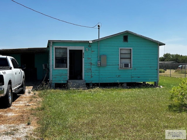 back of house featuring cooling unit and a lawn