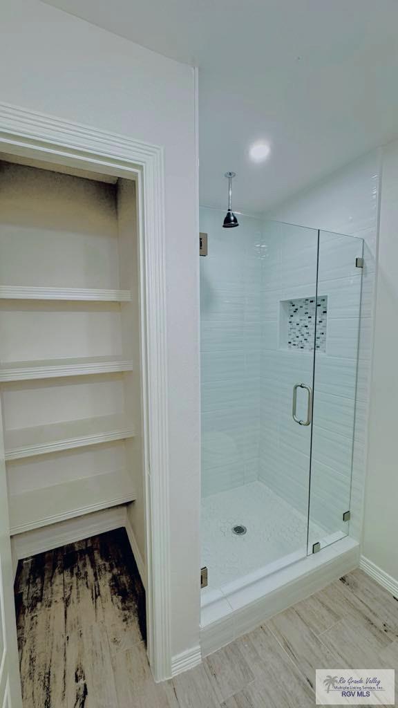 bathroom featuring a shower with shower door