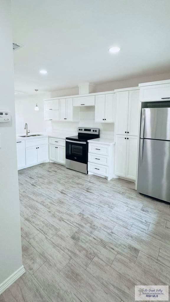 kitchen with sink, white cabinetry, and stainless steel appliances