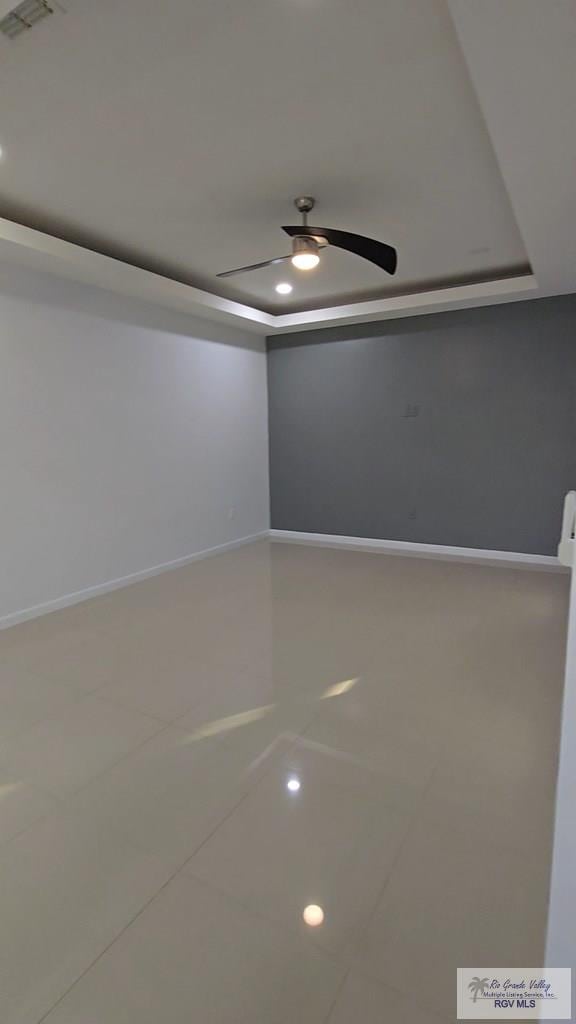 unfurnished room featuring tile patterned floors, ceiling fan, baseboards, and visible vents