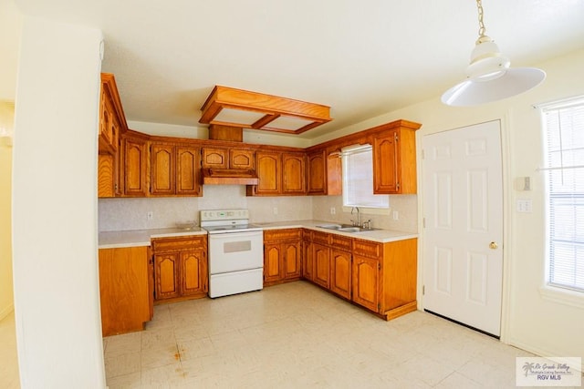 kitchen with white range with electric stovetop, brown cabinets, light countertops, and a sink