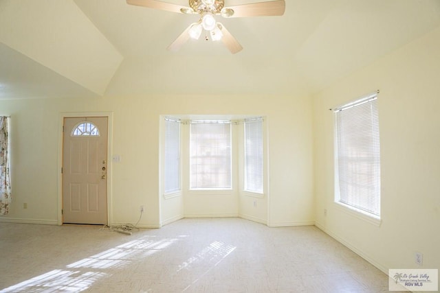 entryway featuring baseboards, a healthy amount of sunlight, ceiling fan, and vaulted ceiling