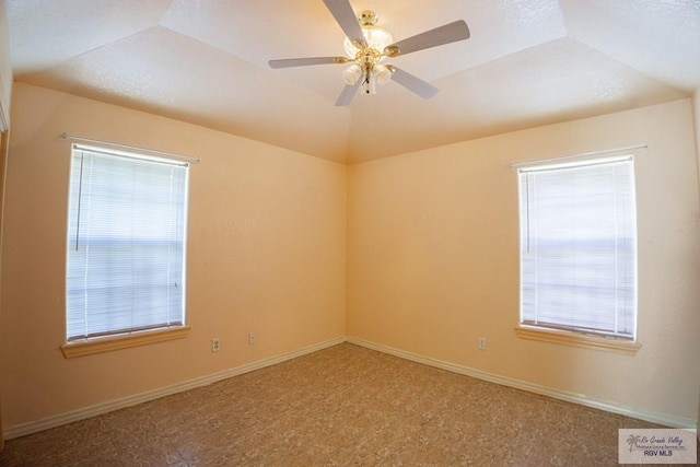 unfurnished room with baseboards, lofted ceiling, and ceiling fan