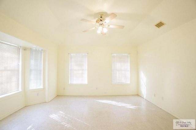 empty room with a ceiling fan, a healthy amount of sunlight, visible vents, and baseboards