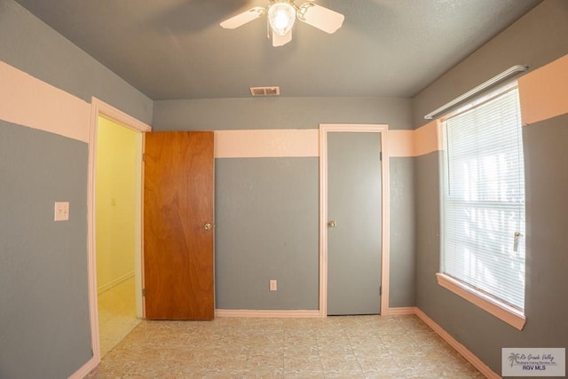 unfurnished bedroom featuring visible vents, baseboards, and a ceiling fan