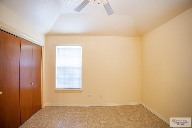 unfurnished bedroom with a closet, baseboards, and lofted ceiling