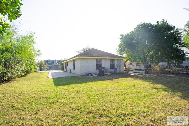 rear view of house with a yard and fence