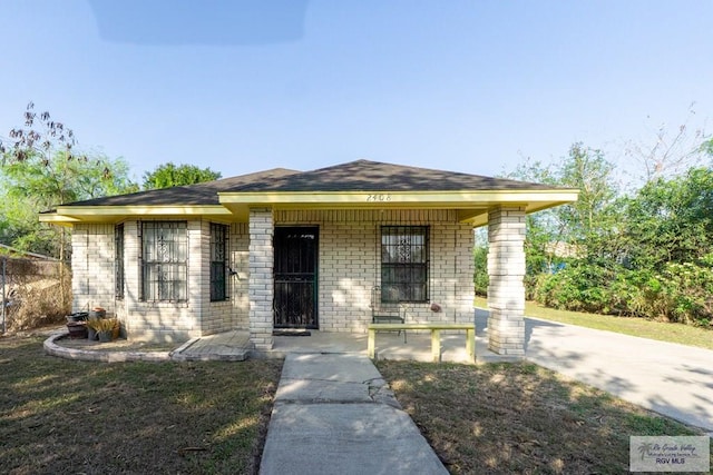 bungalow-style house featuring brick siding, a porch, and a front yard