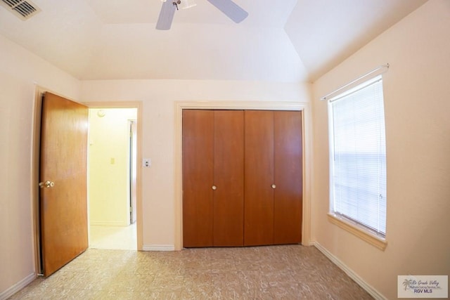 unfurnished bedroom featuring baseboards, visible vents, ceiling fan, vaulted ceiling, and a closet