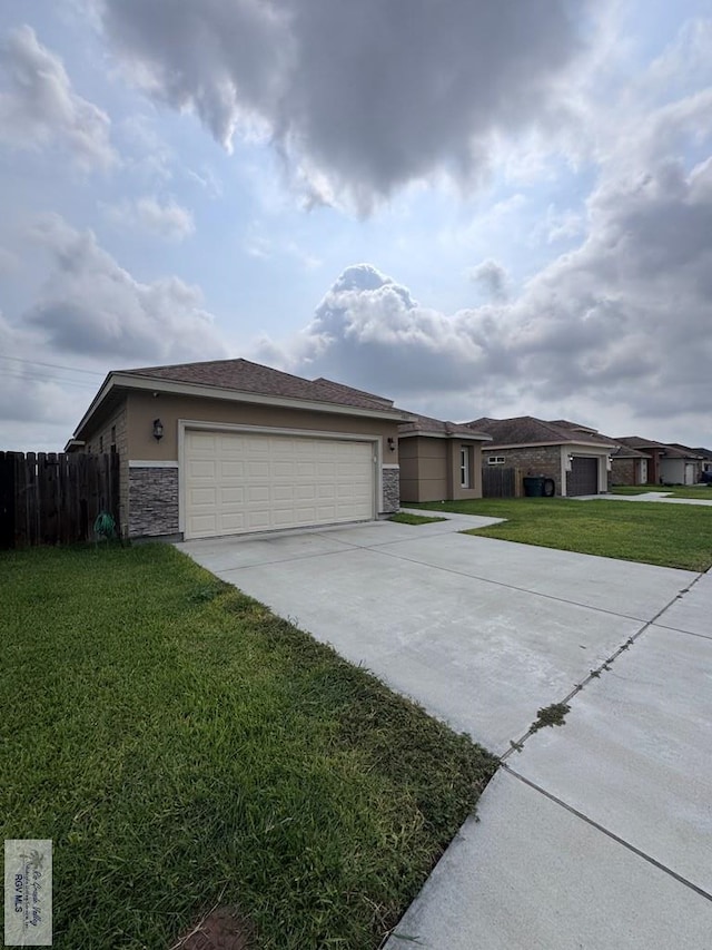 4805 N Westgate Cir, Harlingen, TX 78552 - view of front facade featuring a garage, driveway, stone siding, and stucco siding