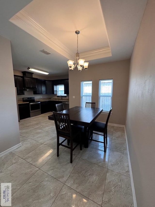 4805 N Westgate Cir, Harlingen, TX 78552 - dining room featuring a tray ceiling, ornamental molding, baseboards, a chandelier, and light marble finish floors