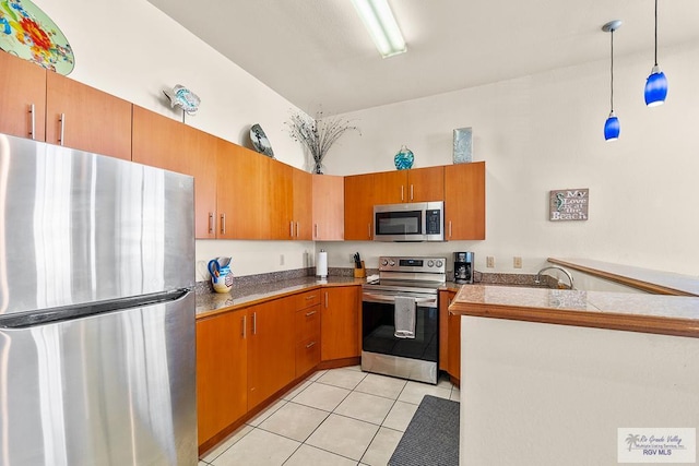 kitchen featuring appliances with stainless steel finishes, pendant lighting, and light tile patterned flooring