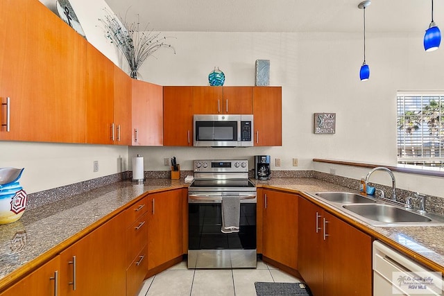 kitchen with hanging light fixtures, sink, light tile patterned floors, and stainless steel appliances