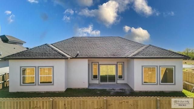 back of property with a shingled roof, a patio area, fence, and stucco siding